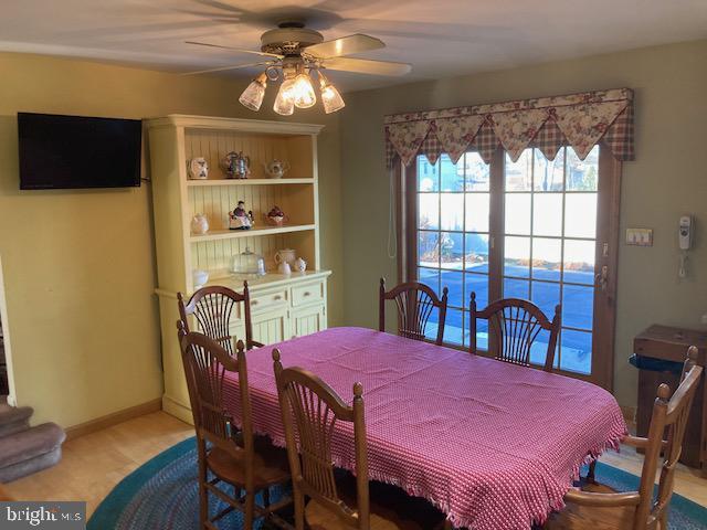 dining space featuring ceiling fan and light colored carpet