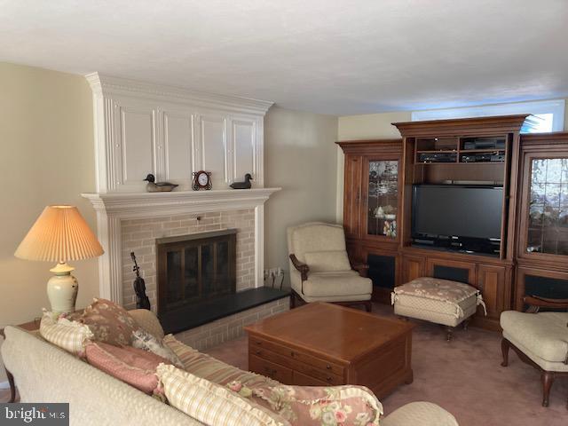 carpeted living room featuring a fireplace