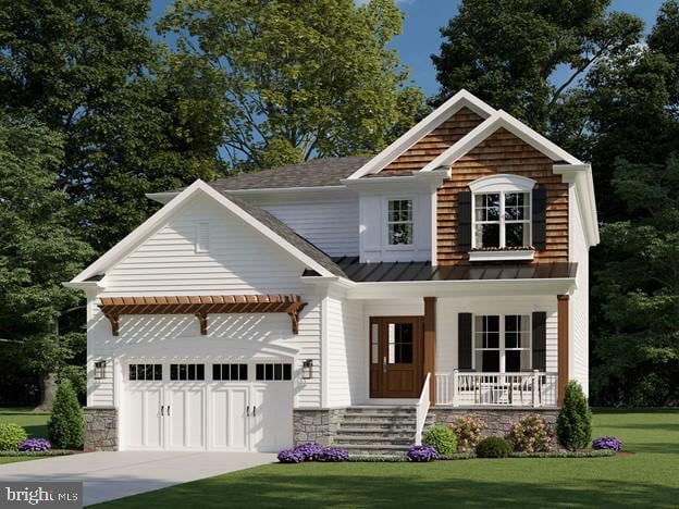 view of front of home featuring a porch, a front yard, a standing seam roof, metal roof, and driveway