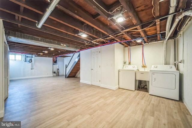 basement featuring washing machine and clothes dryer and hardwood / wood-style floors