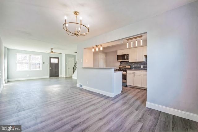 kitchen featuring light hardwood / wood-style floors, white cabinetry, stainless steel appliances, and hanging light fixtures