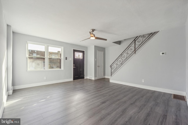 unfurnished living room with dark hardwood / wood-style flooring and ceiling fan