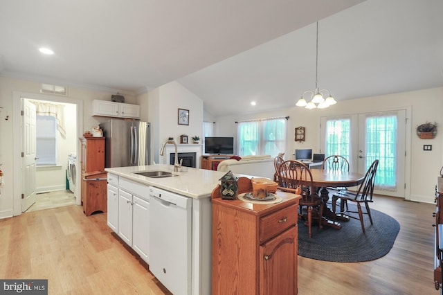 kitchen with dishwasher, white cabinets, a center island with sink, sink, and stainless steel fridge