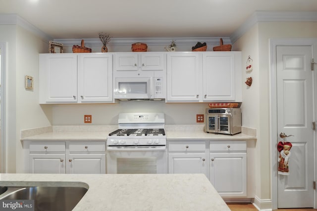 kitchen featuring white appliances, white cabinetry, and ornamental molding