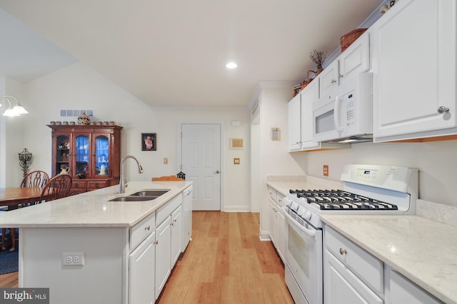 kitchen with white appliances, a center island with sink, sink, light hardwood / wood-style floors, and white cabinetry