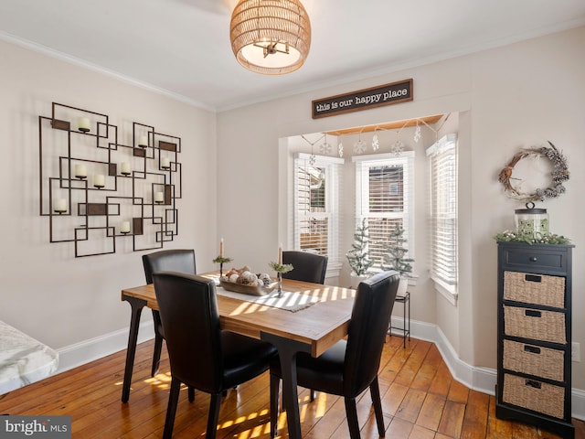 dining space featuring hardwood / wood-style flooring and crown molding