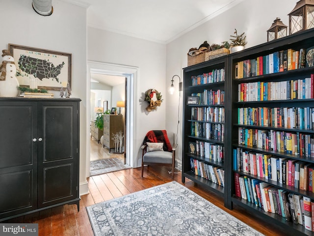 living area featuring crown molding and dark wood-type flooring