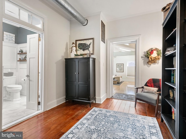 living area featuring dark hardwood / wood-style floors and crown molding