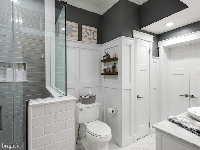 bathroom featuring ornamental molding, vanity, a shower with shower door, and toilet