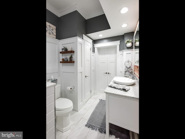 bathroom with vanity, toilet, and crown molding