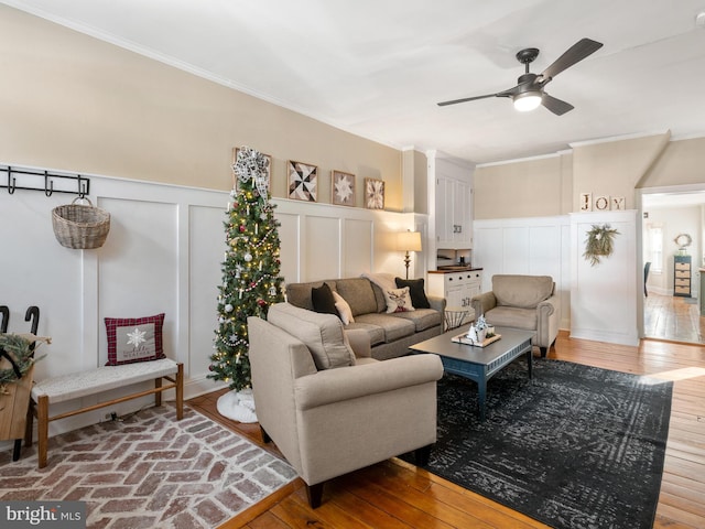 living room featuring ceiling fan, wood-type flooring, and ornamental molding