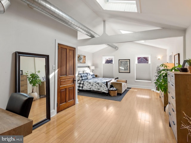 bedroom with light hardwood / wood-style floors and lofted ceiling with skylight