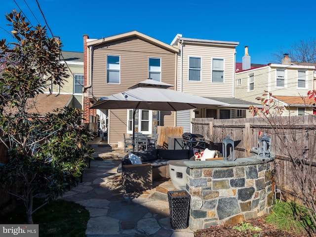 back of property featuring a patio, an outdoor bar, and exterior kitchen