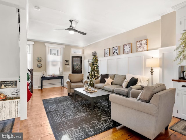 living room with ceiling fan, wood-type flooring, and crown molding