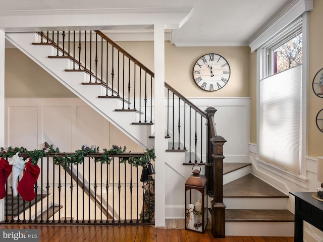 staircase featuring crown molding and hardwood / wood-style flooring