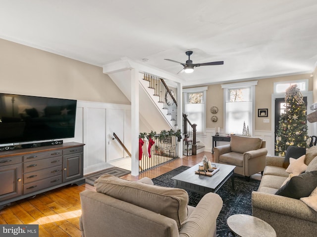 living room featuring ceiling fan, light wood-type flooring, and ornamental molding