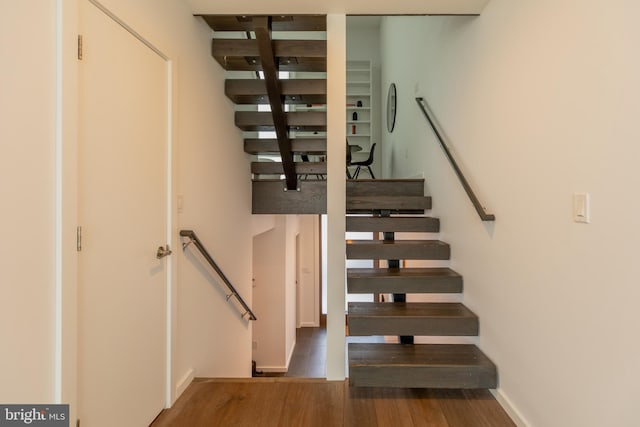 staircase with hardwood / wood-style floors