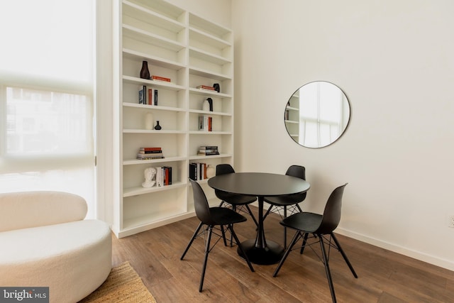 dining area with built in features and hardwood / wood-style flooring