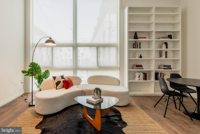 sitting room with built in features and wood-type flooring