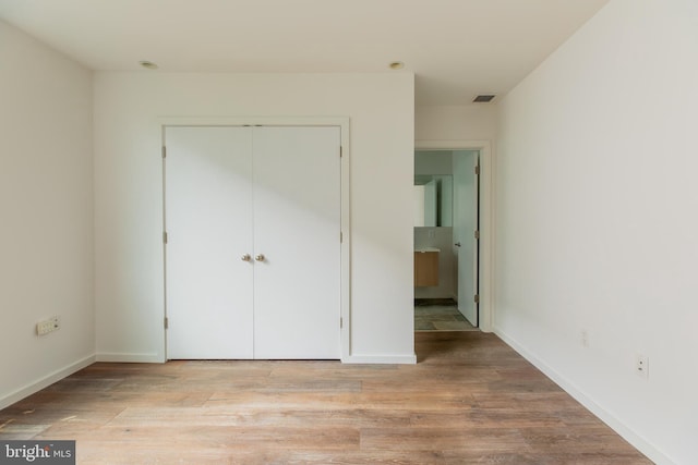 unfurnished bedroom featuring a closet and light hardwood / wood-style flooring