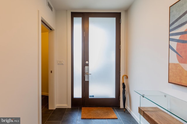 doorway featuring dark tile patterned floors