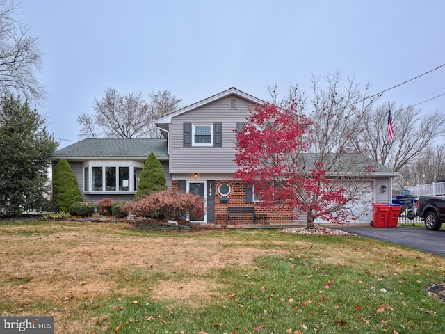 tri-level home featuring a front yard and a garage