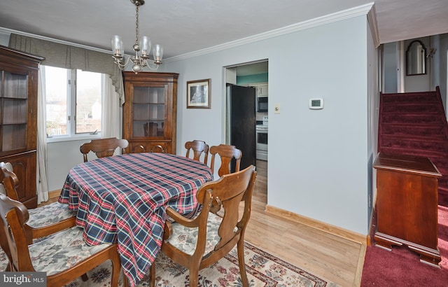 dining room featuring a chandelier, light hardwood / wood-style floors, and ornamental molding