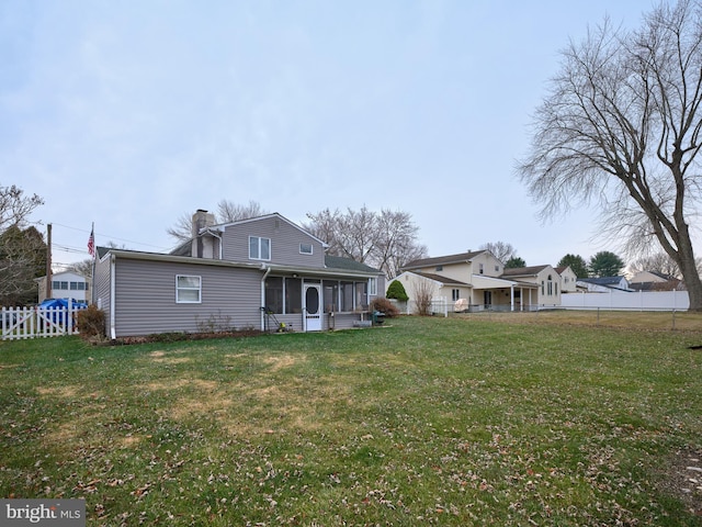 back of property featuring a yard and a sunroom