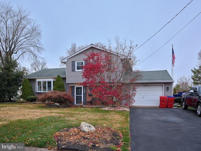 view of front of house with a front yard and a garage