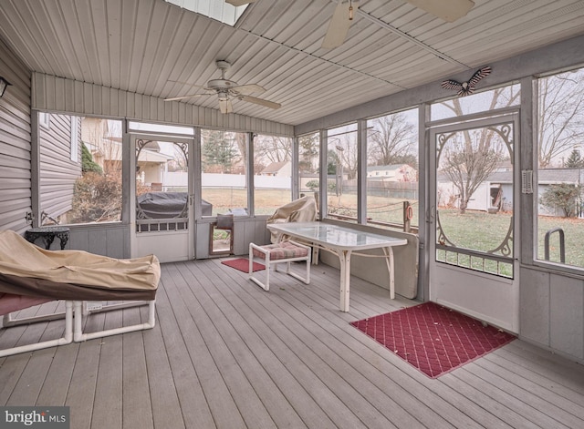 unfurnished sunroom with ceiling fan