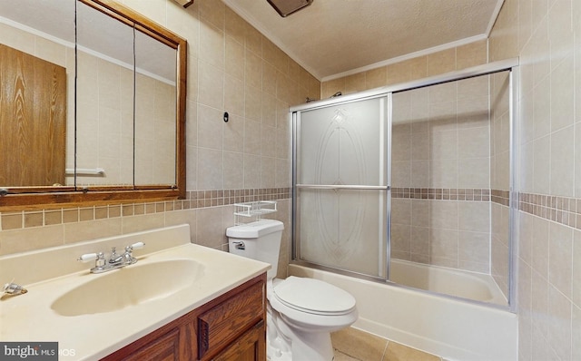 full bathroom with vanity, shower / bath combination with glass door, tile patterned floors, a textured ceiling, and tile walls