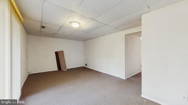 unfurnished room featuring carpet flooring and a drop ceiling