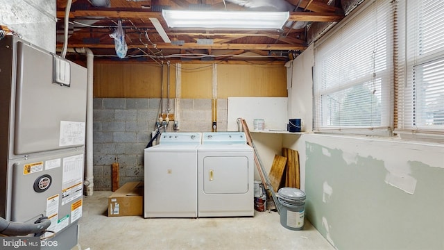 laundry room with heating unit and washer and clothes dryer