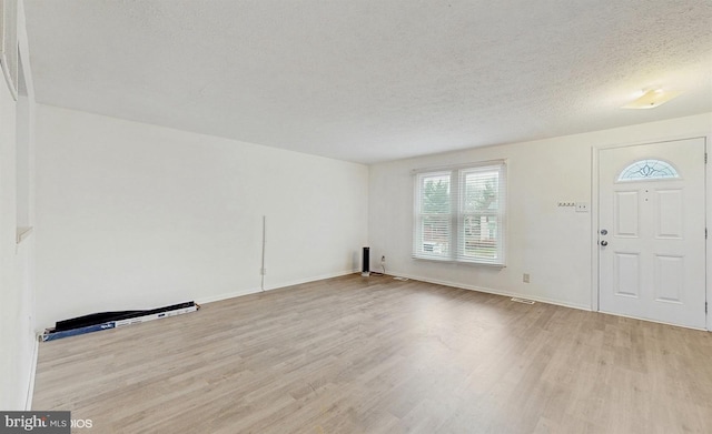 entrance foyer featuring light hardwood / wood-style floors and a textured ceiling