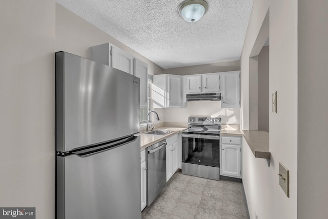 kitchen featuring sink, white cabinets, stainless steel appliances, and a textured ceiling