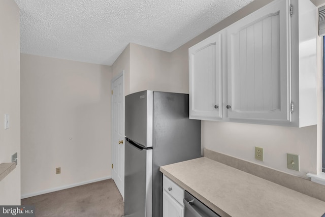 kitchen featuring white cabinets, a textured ceiling, light colored carpet, and stainless steel appliances