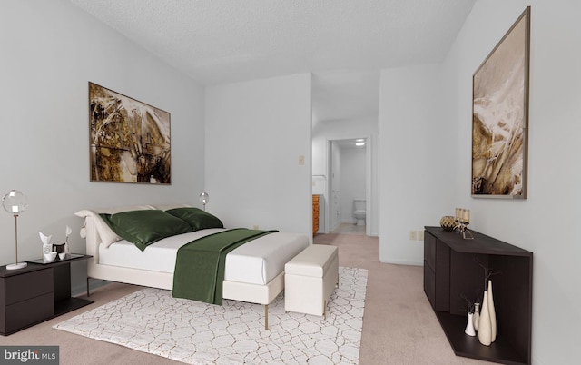 carpeted bedroom with a textured ceiling and ensuite bathroom