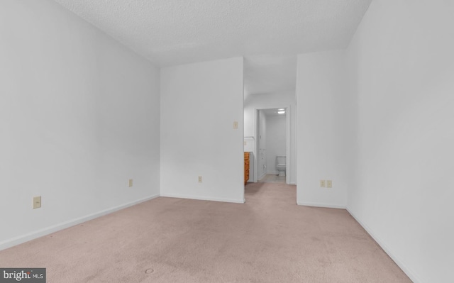 carpeted empty room featuring a textured ceiling