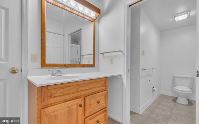 bathroom featuring vanity, toilet, and stacked washer / drying machine