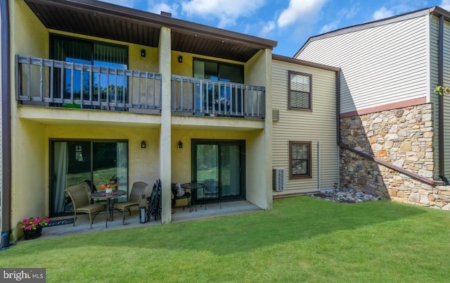 back of house with a balcony, central AC, a patio area, and a lawn