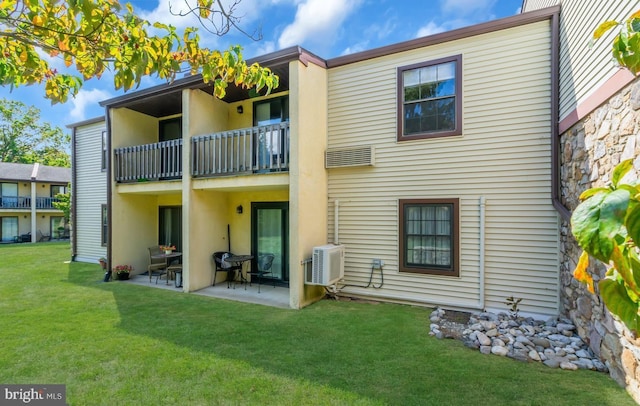 back of property with a yard, a patio, and a balcony