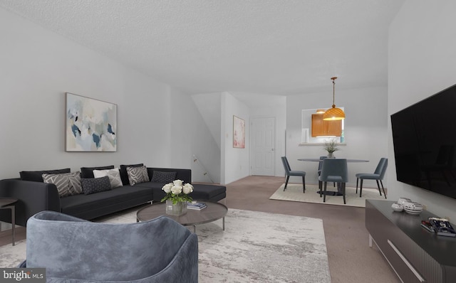 carpeted living room featuring a textured ceiling