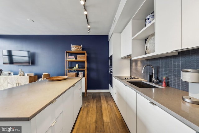 kitchen featuring decorative backsplash, sink, white cabinetry, and built in microwave