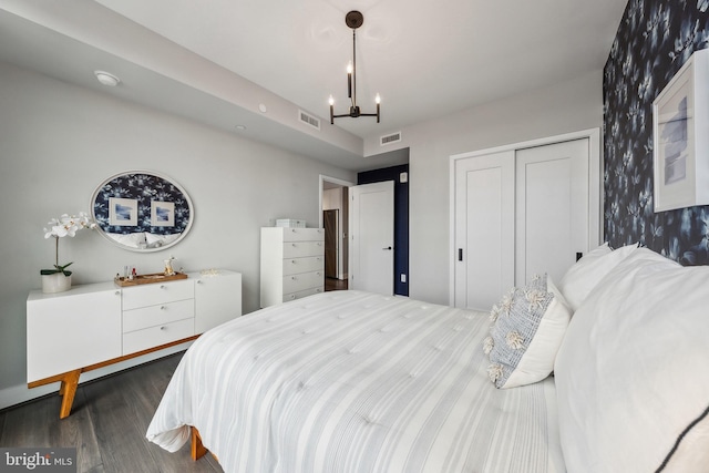 bedroom featuring a closet, a chandelier, and dark hardwood / wood-style flooring