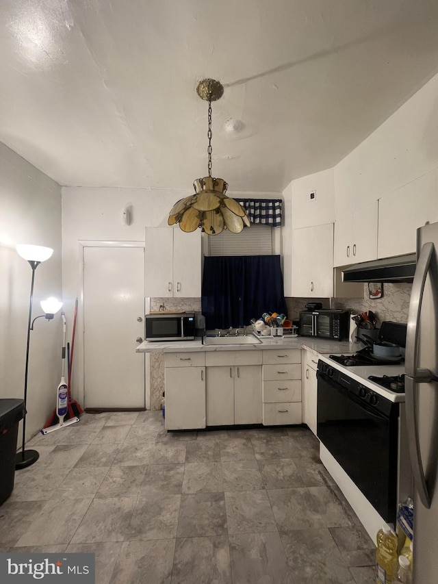 kitchen featuring backsplash, white cabinetry, sink, and appliances with stainless steel finishes