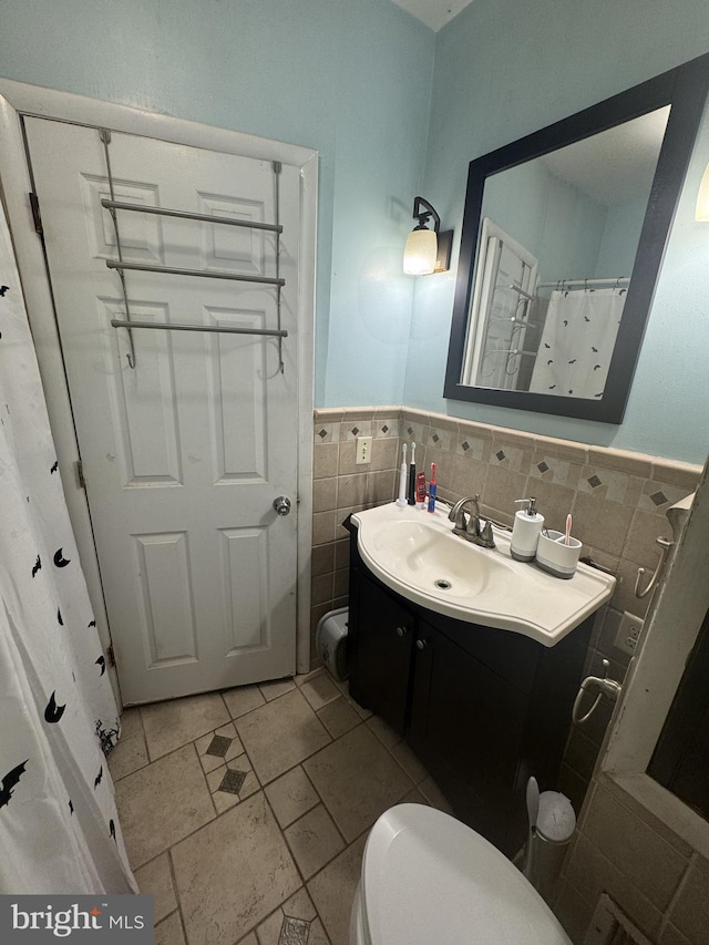 bathroom with vanity, a shower with shower curtain, tile walls, and toilet