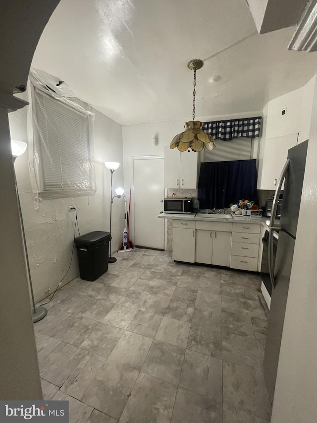 kitchen featuring white cabinets, pendant lighting, sink, and appliances with stainless steel finishes