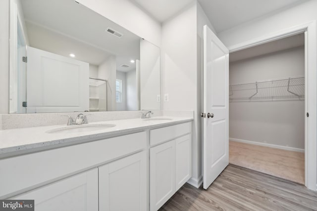 bathroom with vanity, a shower with shower door, and hardwood / wood-style flooring