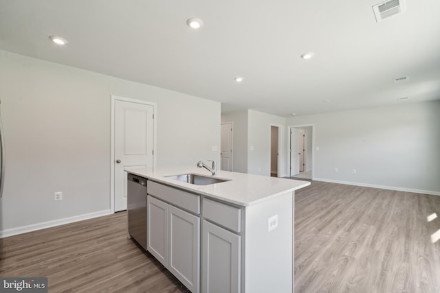 kitchen with light hardwood / wood-style flooring, an island with sink, stainless steel dishwasher, and sink