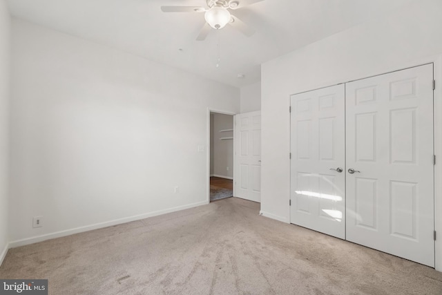 unfurnished bedroom featuring light carpet, a closet, and ceiling fan